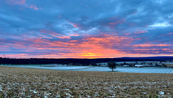 Felder mit etwas Schnee bedeckt, Wolken am Himmel, Abendrot