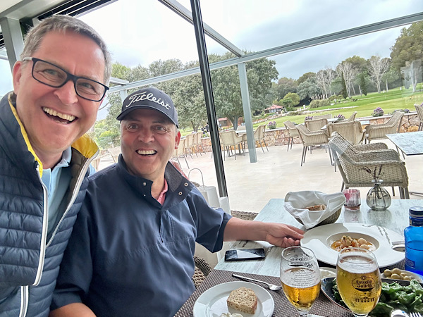 Zwei Männer, einer mit Brille (Martin) und der andere mit Golf-Cap am gedeckten Tisch auf einer Terrasse